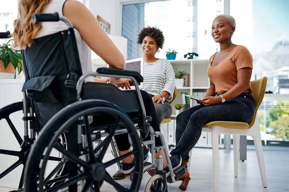 Support workers helping disabled woman in wheelchair with NDIS plan