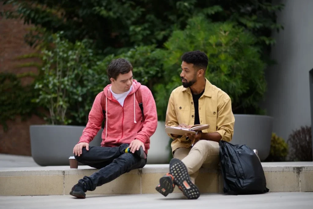 Disabled man with down syndrome sitting with support worker