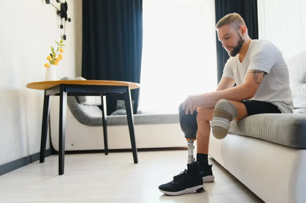 Disabled man with amputated leg getting off couch