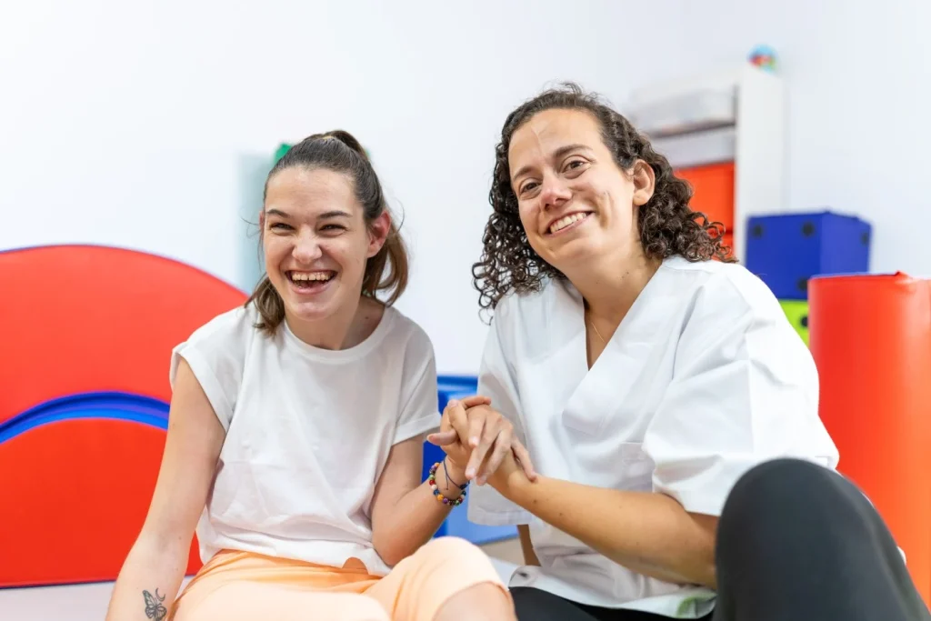 Support worker smiling with disabled girl